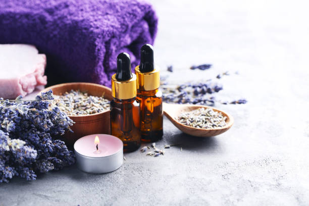 istock Lavender oil with soap and flowers on grey table 667824208