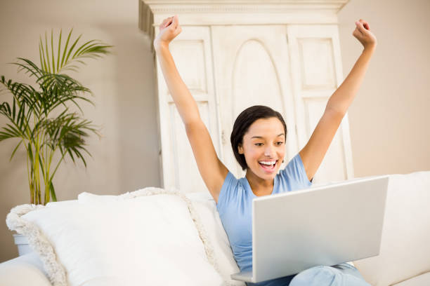 istock Happy woman using laptop and raising arms 667824228