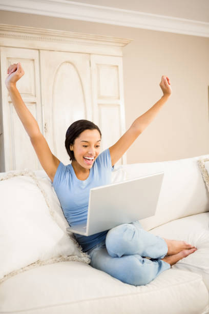 istock Happy woman using laptop and raising arms 667824258