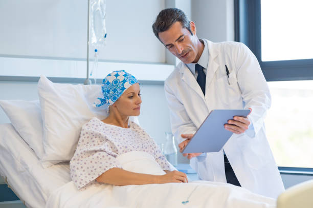 Doctor with cancer patient Doctor telling to patient woman the results of her medical tests. Doctor showing medical records to cancer patient in hospital ward. Senior doctor explaint the side effects of the intervention. cancer illness stock pictures, royalty-free photos & images