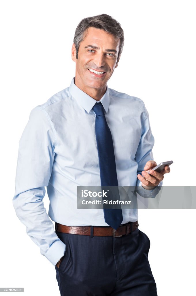 Business man using phone Relaxed mature business man typing message on smartphone and looking at camera. Portrait of a happy senior businessman using cell phone isolated on white background. Businessman Stock Photo