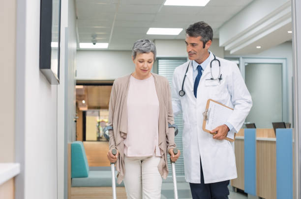 médecin et le patient avec des béquilles - crutch photos et images de collection