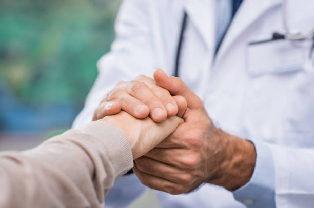 Patient care Close up of doctor hand reassuring her female patient at hospital. Closeup hands of medical doctor carefully holding patient's hands. Kind doctor giving real support for patient. a helping hand photos stock pictures, royalty-free photos & images