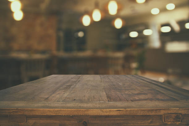 istock wooden table in front of abstract restaurant lights background 667827990