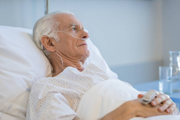 Senior man hospitalized Sad senior man lying on hospital bed and looking away. Old patient with oxygen tube feeling lonely and thinking at hospital. Sick aged man lying hospitalized in a medical clinic. critical care photos stock pictures, royalty-free photos & images