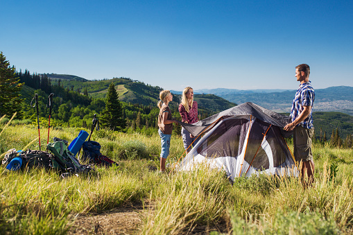 Family of three setting up the tent for camping