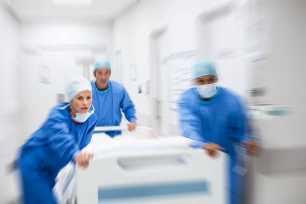 Doctors rushing patient to surgery Nurse and doctor in a hurry taking patient to operation theatre. Patient on hospital bed pushed from surgeon to emergency theatre. Team of doctors and surgeon rushing patient. disaster stock pictures, royalty-free photos & images
