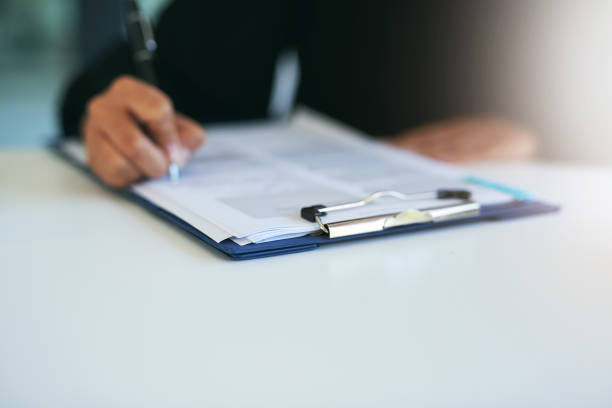 Ticking all the right boxes Closeup shot of a woman writing on a piece of paper filling out stock pictures, royalty-free photos & images