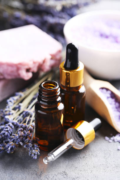 istock Lavender oil with soap and flowers on grey table 667835368