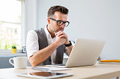 Man in glasses working on laptop from home