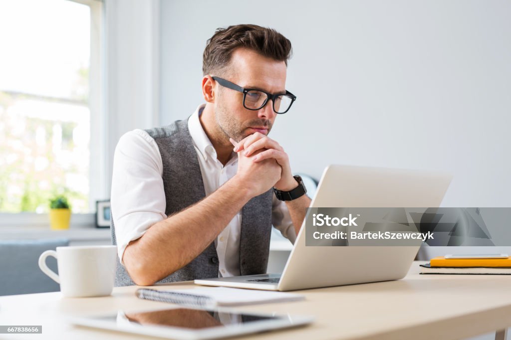 Man in glasses working on laptop from home Laptop Stock Photo