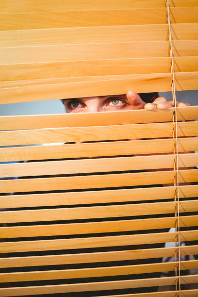 istock Hipster businessman peeking through blinds 667851100