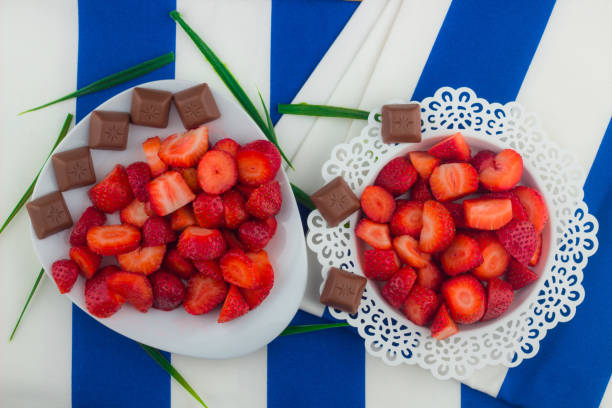 Strawberries on a white plate / Red Freshly cut strawberries on a white artistic plate