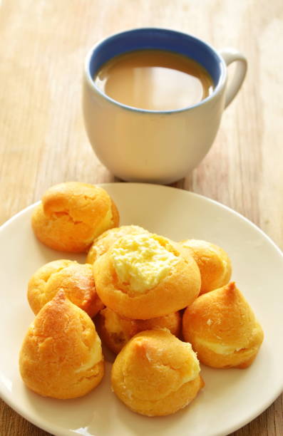istock eclair stuffed vanilla cream on dish and coffee cup 667866482