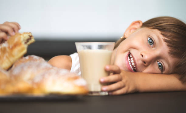 Breakfast happy little girl having breakfast, coffee with croissants at home cerial stock pictures, royalty-free photos & images