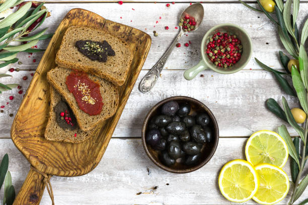 istock Black olives on wooden breakfast table high angle view 667873654