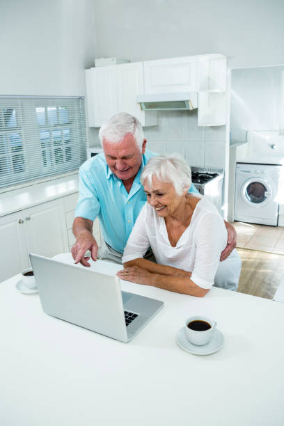 istock Happy senior couple using laptop at table 667873764