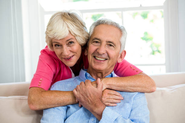 istock Happy senior couple hugging at sofa 667878162