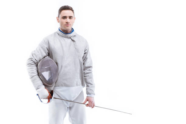 istock Young confident man professional fencer standing with helmet and rapier on white 667879992