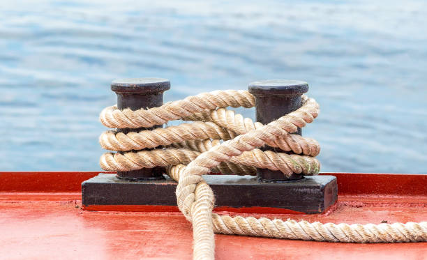 istock Mooring bollard with a fixed rope on the ship against the water background 667887740