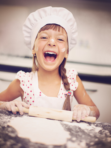 Cooking is fun. Little girl playing with flour 