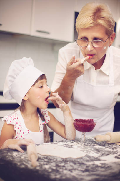 готовка - grandmother domestic life cooking domestic kitchen стоковые фото и изображения