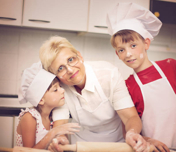 готовка - grandmother domestic life cooking domestic kitchen стоковые фото и изображения