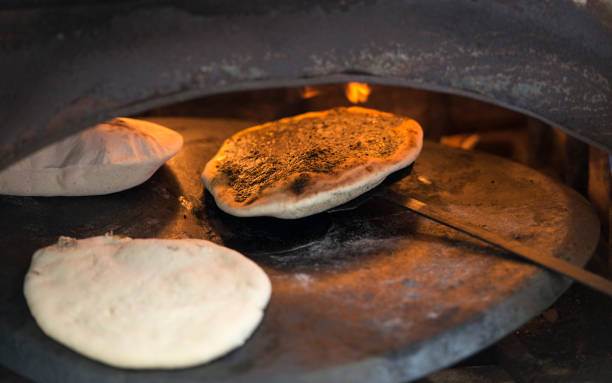 cottura del pane nel forno taboon. - spice market israel israeli culture foto e immagini stock