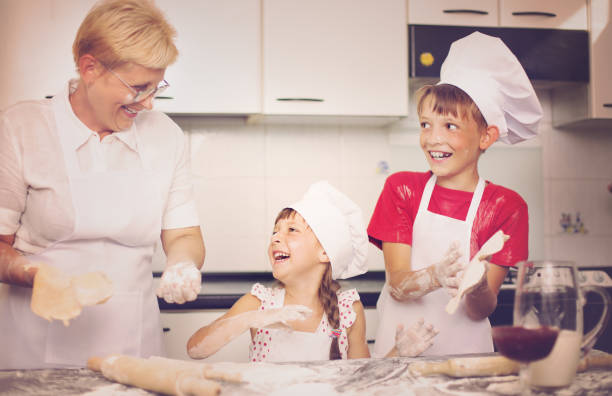 готовка - grandmother domestic life cooking domestic kitchen стоковые фото и изображения
