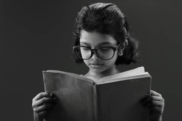 istock Girl wearing big spectacle reads a book 667903634