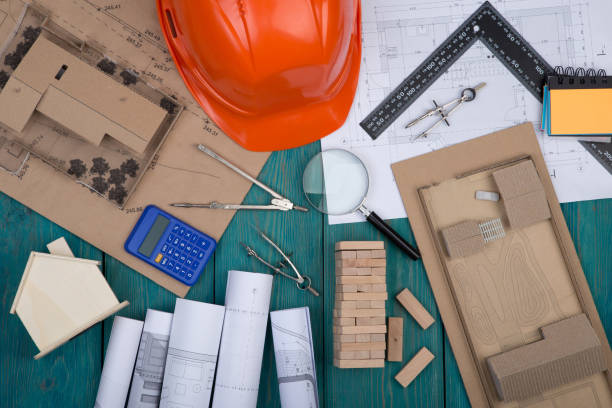 istock construction drawings, engineering tools, little house, model house, calculator, helmet 667910016