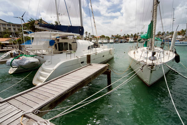 Catamaran and a sailboat moored at the port of Aruba on a sunny day stock photo