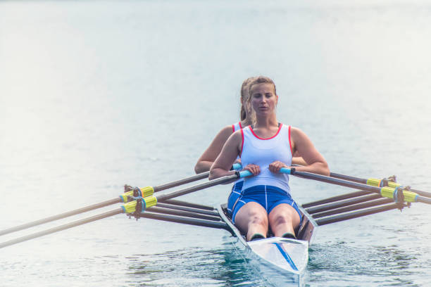 dwie kobiety wiosłowania na jeziorze - team sport rowboat sports team nautical vessel zdjęcia i obrazy z banku zdjęć