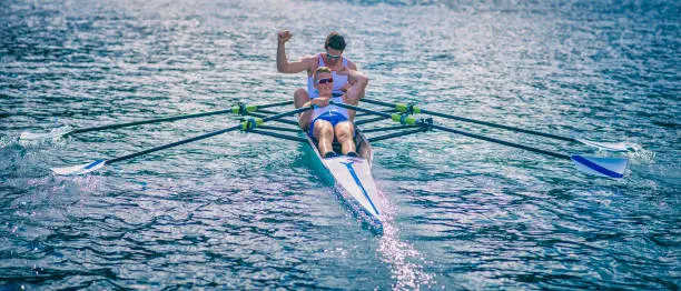 Front view of a coxless pair in a sport rowboat after winning a race on a lake, copy space.