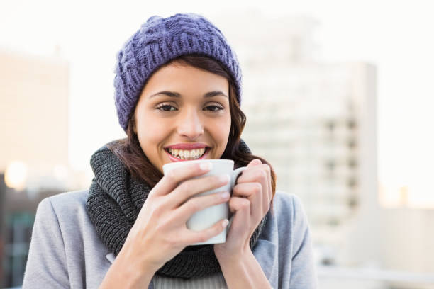 istock Smiling woman drinking hot beverage 667932482