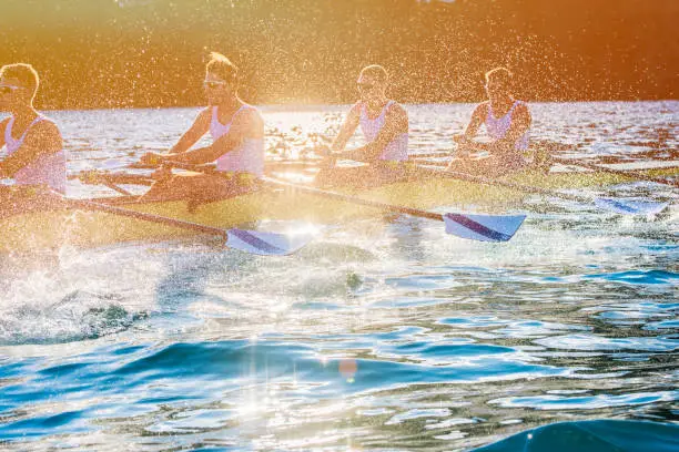 Side view of a coxless four training on a lake, copy space.