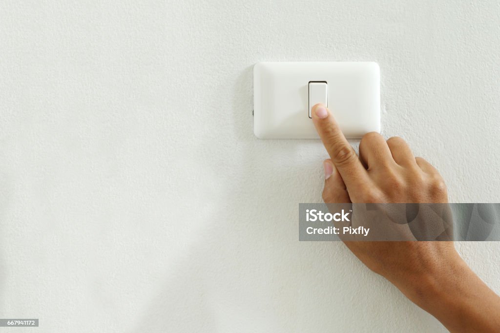 closeup of finger touching to electric switch off with copy space save energy concept closeup of finger touching to electric switch off with copy space Light Switch Stock Photo