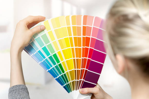 istock woman selecting home interior paint color from swatch catalog 667946588