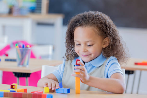 istock Little girl concentrates while counting blocks 667947044