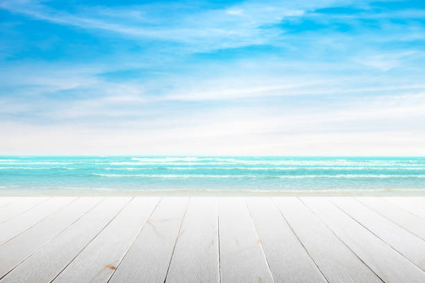 Empty wooden table with party on beach background blurred. stock photo