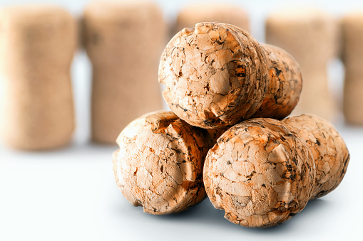 Close-up in studio, of group of three beer corks in stack clean brown bottle stopper in selective focus on white background. Drinks utensil.