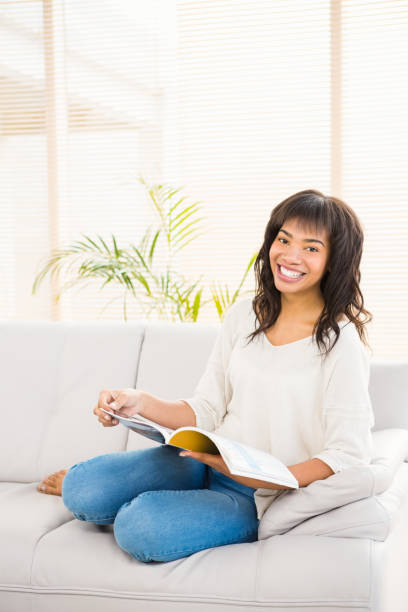 istock Pretty woman reading on couch 667993128