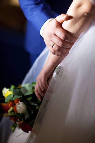 istock Bride hands with ring and wedding bouquet of flowers 667998816