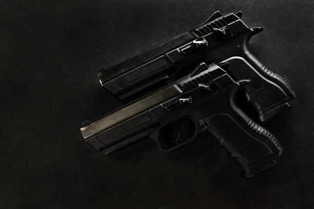 istock handguns in a row on the black background 667999308
