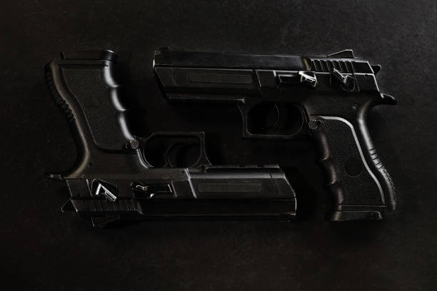 istock handguns in a row on the black background 668000192