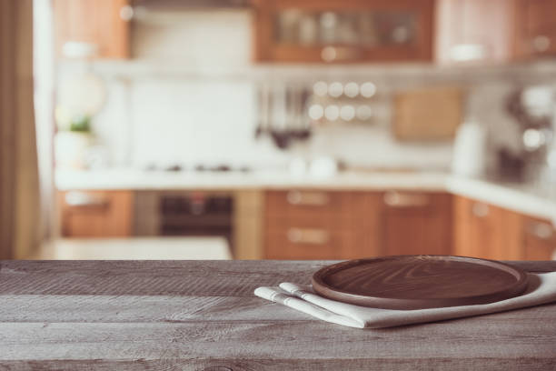 istock Blurred and abstract background. Empty wooden tabletop and defocused modern kitchen background for display or montage your products. Toned image. 668012838