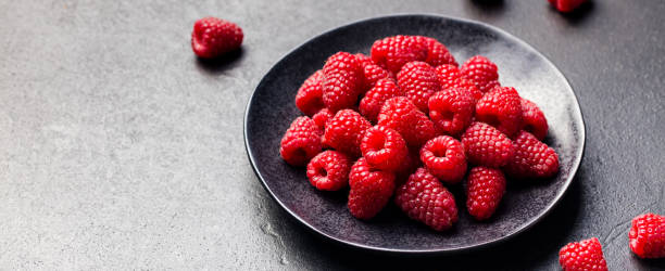 istock Fresh raspberries on a black bowl Slate background 668023146