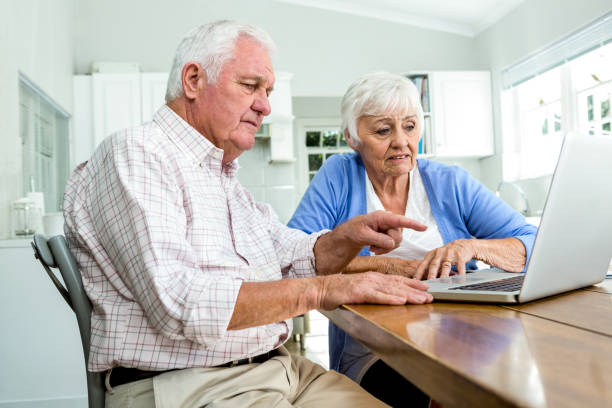 istock Serious retired man pointing at laptop 668026078