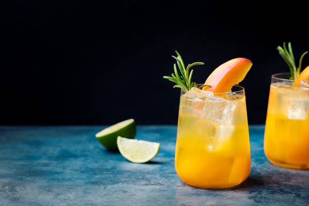 istock Peach cocktail, fizz with rosemary on blue stone background. Copy space 668026138