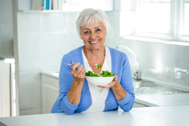 istock Happy senior woman with salad in kitchen 668027536